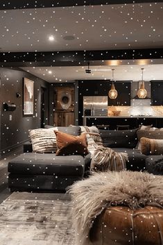 a living room filled with lots of furniture and snow falling on the ground in front of it