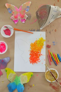 the child's artwork is being made with colored crayons and watercolors