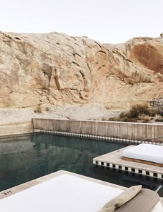 there is a pool in the middle of an outdoor area with water and rocks behind it