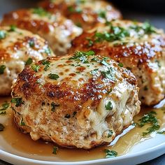 some meat patties on a plate with sauce and parsley sprinkled on top