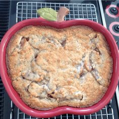 an apple shaped dish sitting on top of a metal rack in front of a stove