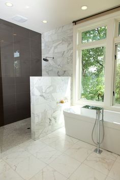 a large bathroom with marble tile flooring and white walls, along with a walk in shower