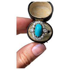 A bright robin’s egg blue turquoise cabochon is perfectly framed in halo of sparkling single-cut and old mine-cut diamonds. This Edwardian treasure is crafted in platinum topped 14k yellow gold. Currently a finger size 4.5. Measurements: 18.80 x 17.12 mm Turquoise: 12.61 x 6.77 x 6.45 mm deep, lovely matrix on the back Diamonds: 14 single-cut diamonds estimated .50 total carats, two old mine-cut diamonds estimated .30 total carat weight. I-J range in color, SI2 - I1 range in clarity Metal: platinum over 14K Weight: 4.1 grams Turquoise And Diamond Ring, Turquoise Diamond Rings, Blue Turquoise, Cocktail Rings, Turquoise Blue, Diamond Cuts, Halo, Diamond Ring, Platinum