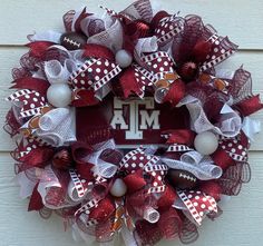 a red and white mesh wreath with footballs, balls and letters on the front door