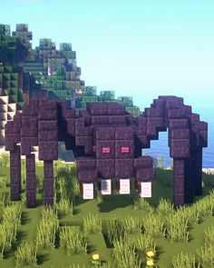 an animal made out of blocks in the middle of some grass and trees with water in the background