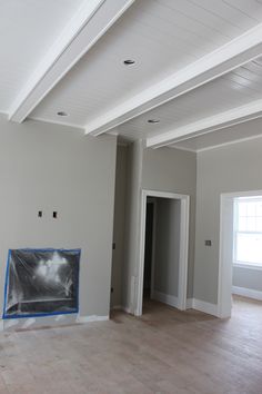 an empty living room with white walls and wood flooring is being painted in the process of remodeling