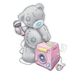 a teddy bear sitting on top of a pink camera