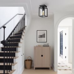 a hallway with stairs and a cabinet in it