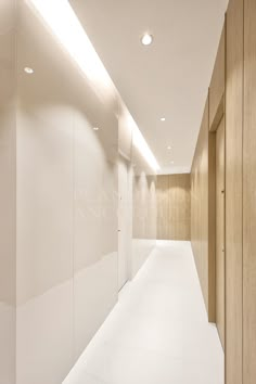 an empty hallway with white walls and wood paneling