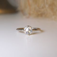 a white diamond ring sitting on top of a table