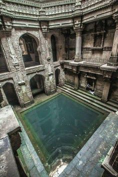 an old building with a pool in the middle