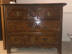 an old wooden dresser with many drawers and knobs on it's sides, next to a trash can