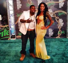 a man standing next to a woman on a green carpet