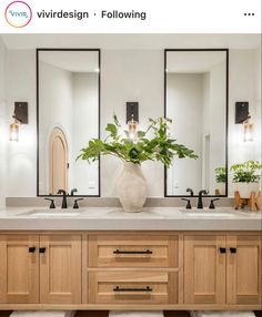 a bathroom with two sinks and three mirrors on the wall next to plants in a vase