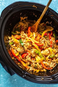 a slow cooker filled with shredded chicken and peppers