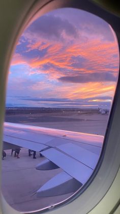 an airplane window looking out at the sunset