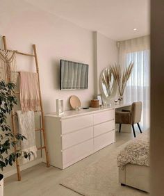 a living room filled with furniture and a flat screen tv on top of a dresser