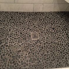 a shower stall with an animal print pattern on the floor and drain in the middle