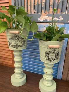 two green planters sitting on top of a wooden table