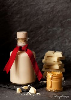 a bottle of peanut butter with a red ribbon around it next to some pieces of bread