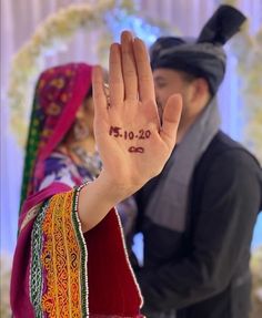 a man and woman are holding their hands up in the air with numbers written on them