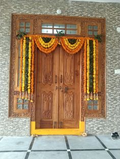 a wooden door decorated with flowers and garlands on the front entrance to a building