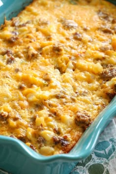 a casserole dish with meat and cheese in it sitting on a tablecloth