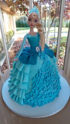 a barbie doll cake with blue frosting on it