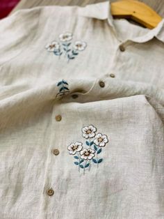 the shirt is white and has blue flowers on it