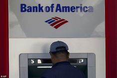 a man standing in front of a bank of america atm machine