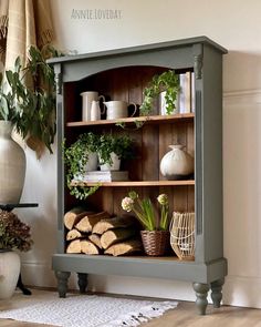 a shelf filled with lots of plants next to a potted plant on top of a table