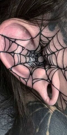 a person with spider web tattoos on their ear