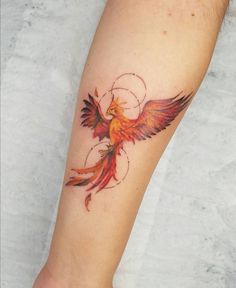 a woman's arm with a bird tattoo on it