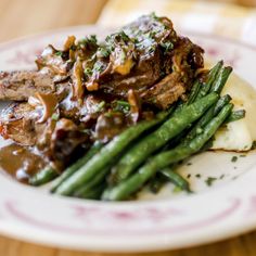 a white plate topped with meat and green beans