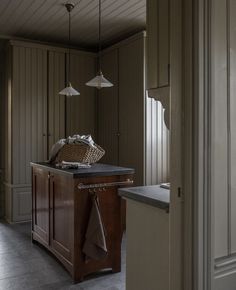 a kitchen with an island and hanging lights