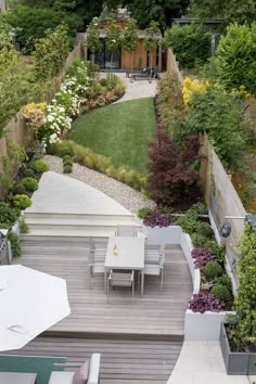 an outdoor dining area with wooden decking and white umbrellas in the middle of it