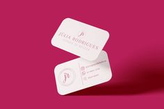 two business cards sitting on top of each other in front of a pink background with the logo