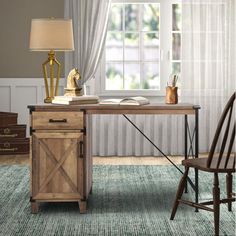 a wooden desk sitting in front of a window with a lamp on top of it