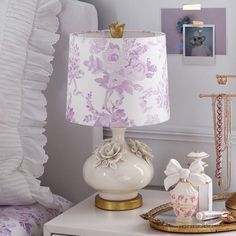 a white table with a lamp on top of it next to pictures and other items