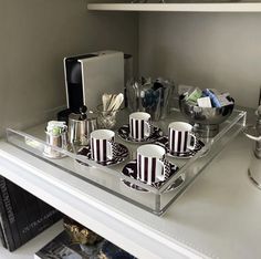 there are cups and saucers on the shelf