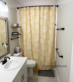 a bathroom with a sink, toilet and shower curtain is shown in this image from the front view