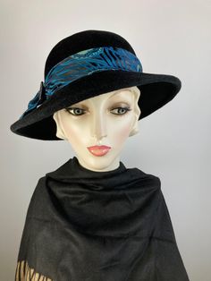 What a classic and classy black wool felt winter hat! This pretty black wool felt hat isn't a true fedora, but it has a similar feel but with a feminine spin. Instead of the top having a point at the front, it has a smooth oval crown. It's hand blocked over wooden hat blocks and hand sewn. The asymmetrical brim is also wider than a traditional fedora.  The band and bow are made with a black, teal and mint green fabric and then topped with a faceted black glass vintage button. This one simply never goes out of style. Handmade in the USA. In stock and ready to ship. One of a kind hat. FIT AND SIZE: Head size: 21 to 23 inches.  Inner adjustable grosgrain ribbon headband. Brim width 2 1/2 inches in the back left side, and 3 inches in the front and right side. HOW TO MEASURE YOUR HEAD SIZE: Pla Formal Wool Felt Hat For Winter, Evening Hats With Curved Brim For Fall, Evening Fall Hat With Curved Brim, Curved Brim Evening Hat For Fall, Wool Wide Brim Top Hat For Winter, Fitted Wool Cloche Hat, Winter Wool Wide Brim Top Hat, Winter Wide Brim Wool Top Hat, Formal Winter Felt Hat Bands