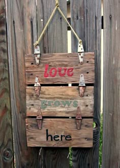 a wooden sign hanging on the side of a fence