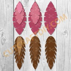 three pink and brown feathers cut out from paper on a white wooden background with the words,