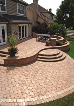 a brick patio with steps and seating area