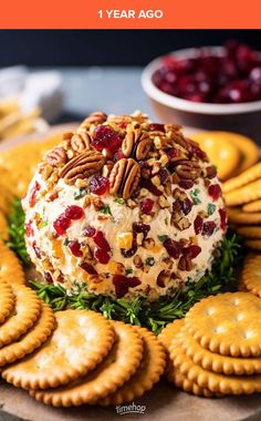 cheese ball with cranberry sauce and pecans on top surrounded by crackers