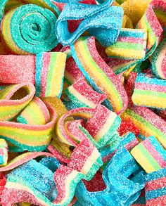 there are many different colors of candy in the pile, including rainbows and swirls