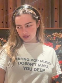 a young woman wearing a t - shirt that says hating pop music doesn't make you deep