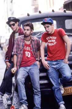 three young men sitting on the back of a truck