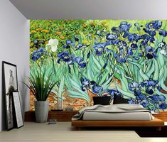 a bedroom with blue flowers painted on the wall and a bed in front of it